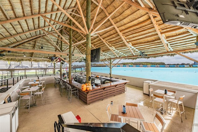 exterior space with a gazebo, a water view, an outdoor bar, and a view of the beach