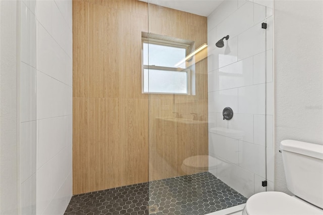 bathroom featuring toilet and a tile shower