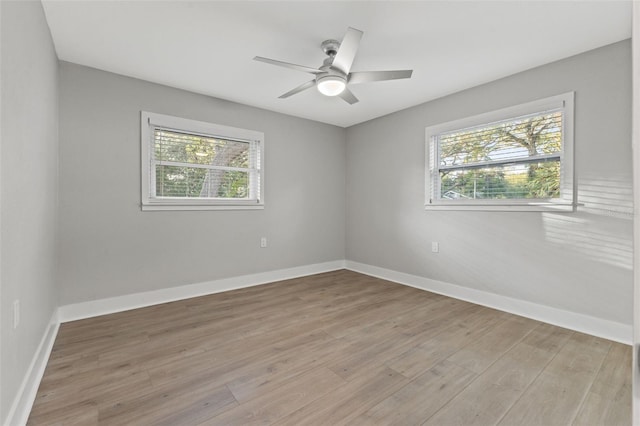 empty room with ceiling fan and light hardwood / wood-style flooring