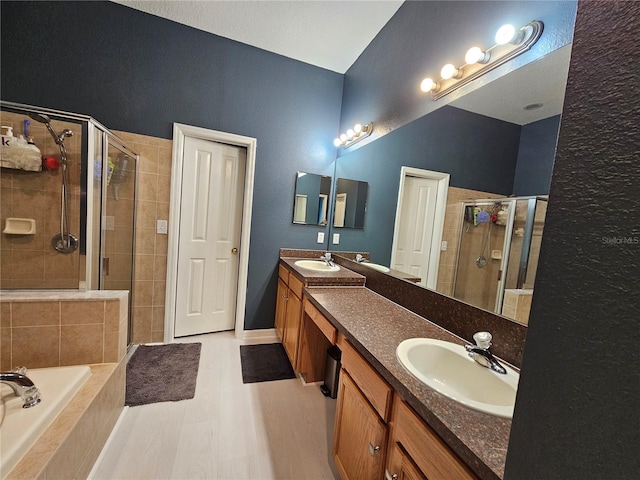 bathroom with vanity and shower with separate bathtub