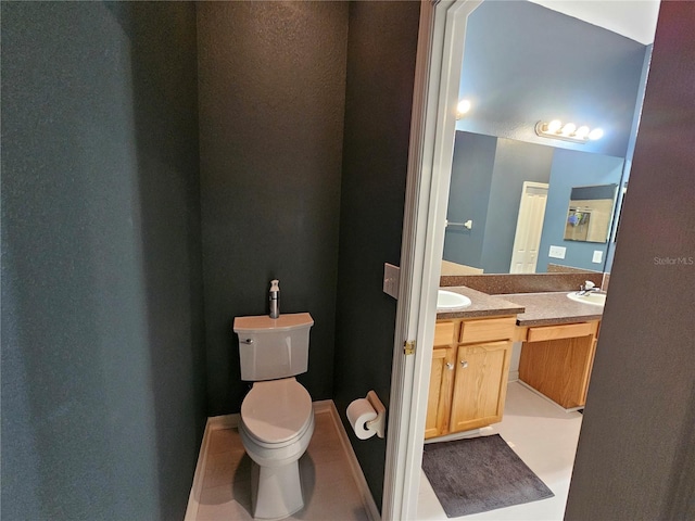 bathroom featuring tile patterned flooring, vanity, and toilet