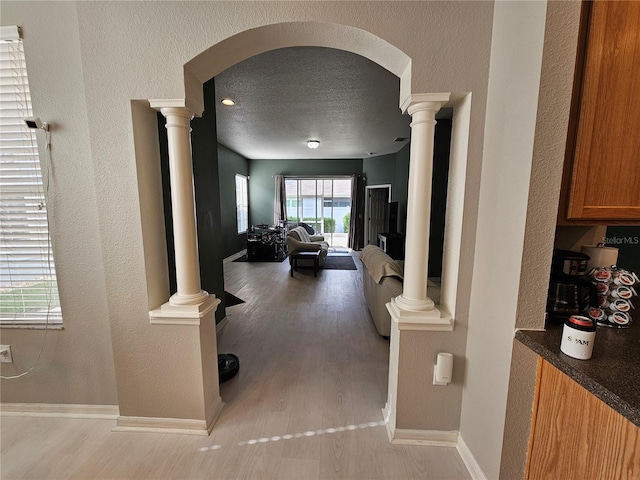 hallway with a textured ceiling and light wood-type flooring