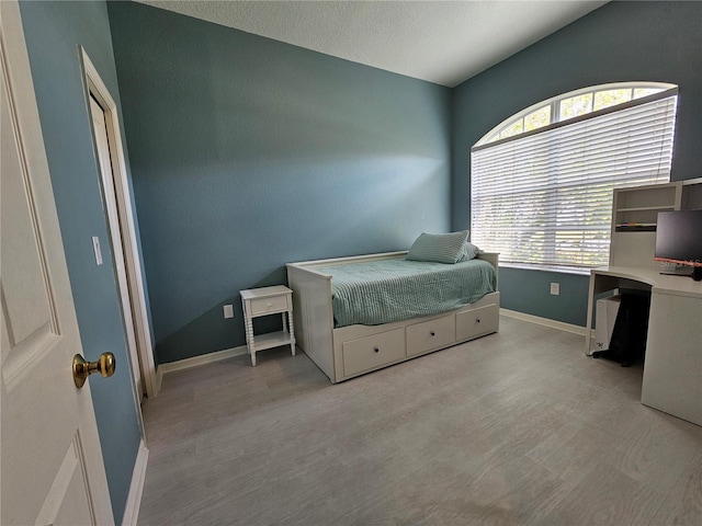 bedroom with a textured ceiling and light hardwood / wood-style flooring