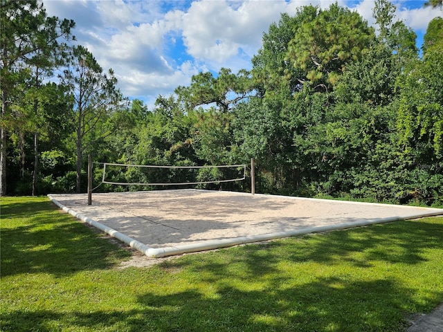 view of community featuring volleyball court and a lawn