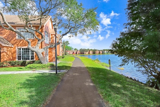 view of community with a lawn and a water view