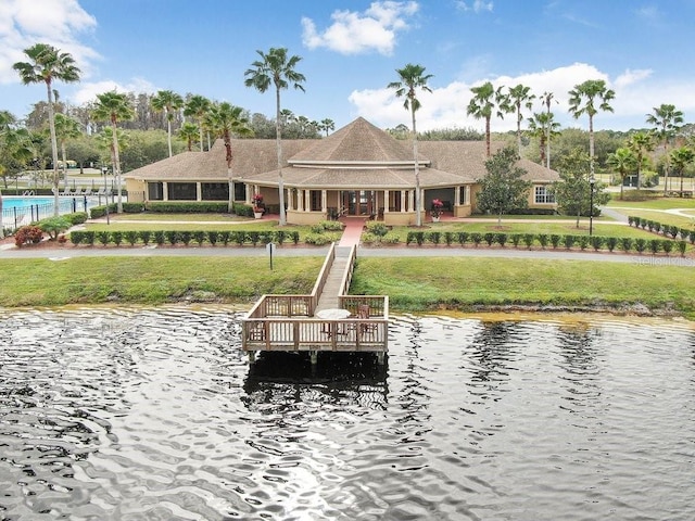 exterior space featuring a lawn and a deck with water view