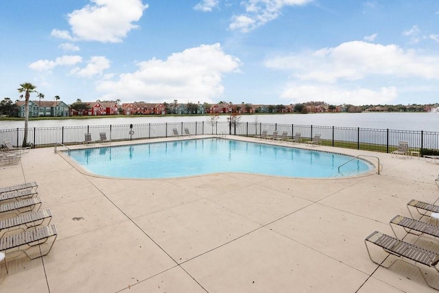 view of swimming pool featuring a water view and a patio area