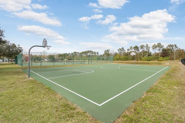 view of basketball court with tennis court and a yard