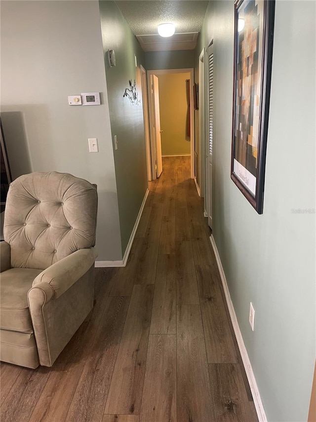 corridor with dark hardwood / wood-style flooring and a textured ceiling