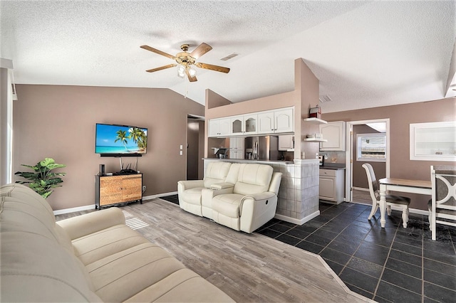 living room featuring a textured ceiling, ceiling fan, dark hardwood / wood-style floors, and vaulted ceiling