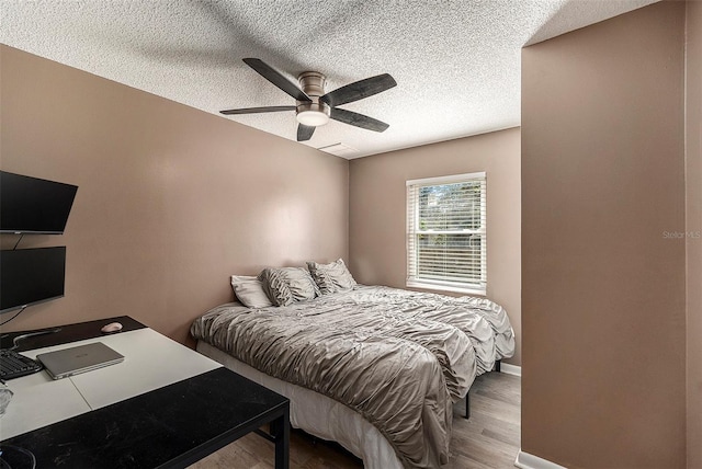 bedroom featuring a textured ceiling, light hardwood / wood-style flooring, and ceiling fan