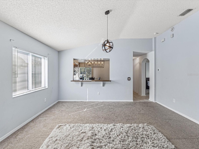 unfurnished room with carpet, lofted ceiling, and a textured ceiling