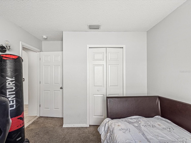 carpeted bedroom featuring a closet and a textured ceiling