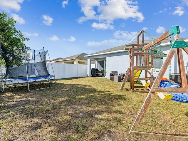 view of yard with a playground and a trampoline