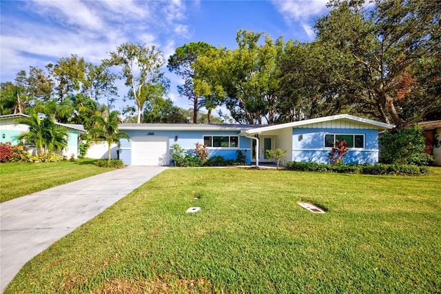 1042 Idlewild Dr N, Dunedin, FL 34698 - ranch-style home featuring a garage, a front lawn, concrete driveway, and stucco siding