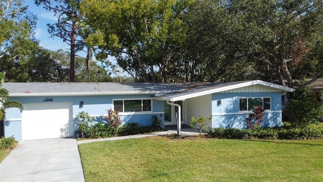 1042 Idlewild Dr N, Dunedin, FL 34698 - ranch-style home featuring a garage, a front yard, driveway, and stucco siding