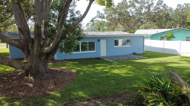 rear view of house featuring a yard