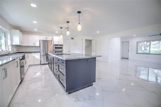 1042 Idlewild Dr N, Dunedin, FL 34698 - kitchen with stainless steel appliances, light marble finish flooring, light stone counters, a kitchen island, and recessed lighting