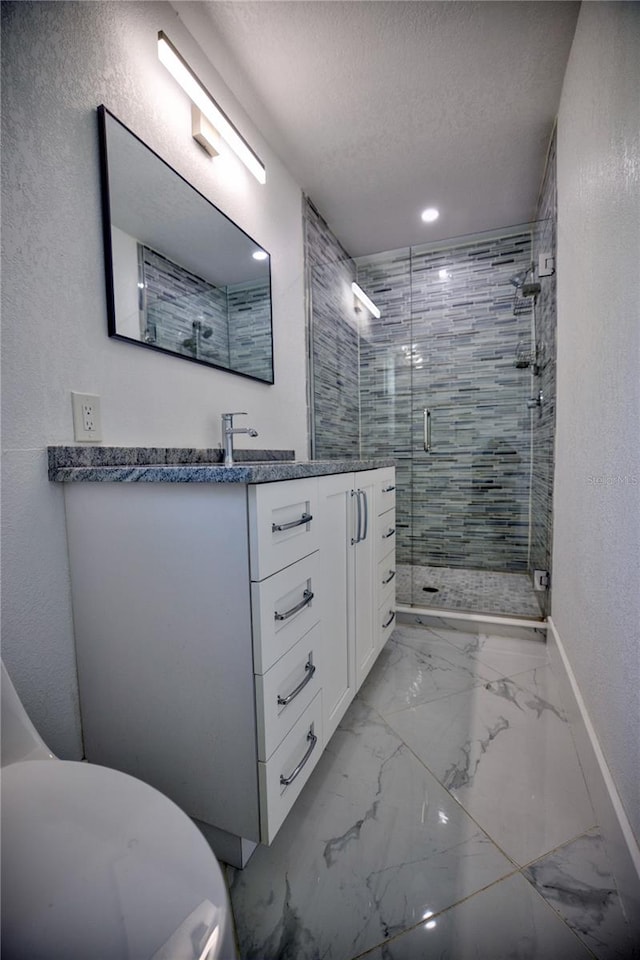 bathroom with vanity, a shower with shower door, and a textured ceiling