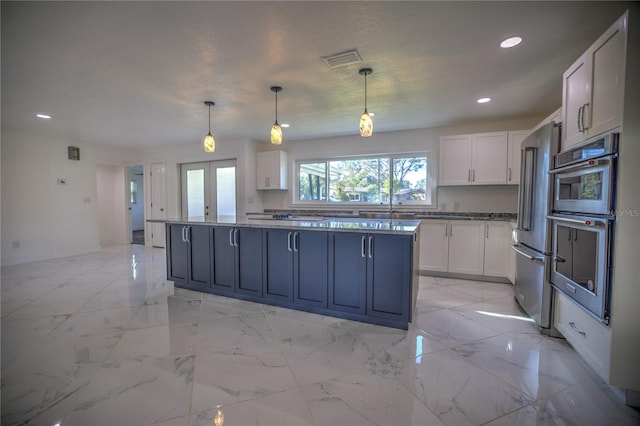 kitchen with white cabinetry, french doors, pendant lighting, and appliances with stainless steel finishes