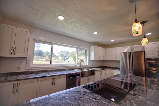 1042 Idlewild Dr N, Dunedin, FL 34698 - kitchen with stainless steel appliances, a sink, a textured ceiling, recessed lighting, and white cabinets