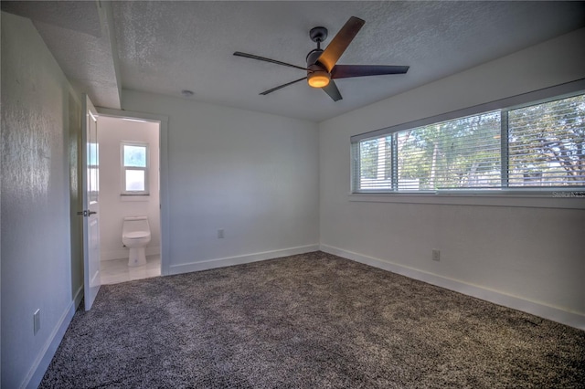 unfurnished bedroom with ensuite bath, ceiling fan, carpet, and a textured ceiling