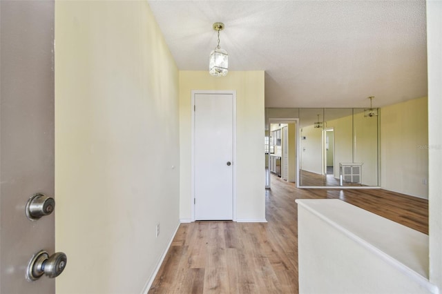 8198 Terrace Garden Dr N Unit 403, Saint Petersburg, FL 33709 - hall with wood finished floors, baseboards, and a textured ceiling