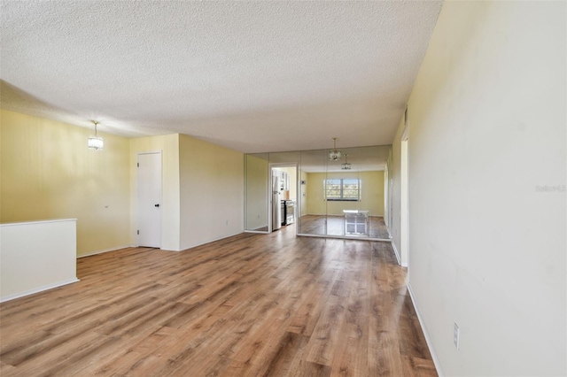 8198 Terrace Garden Dr N Unit 403, Saint Petersburg, FL 33709 - unfurnished living room with wood finished floors, a textured ceiling, and baseboards