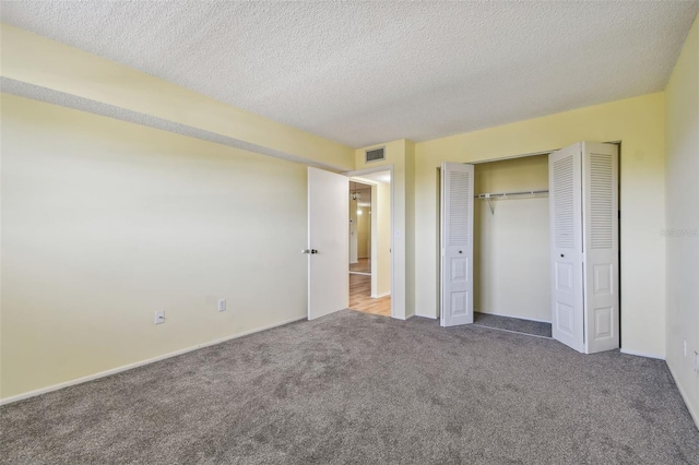 unfurnished bedroom featuring carpet flooring, a closet, and a textured ceiling