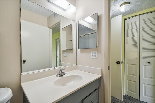 8198 Terrace Garden Dr N Unit 403, Saint Petersburg, FL 33709 - bathroom with a closet, vanity, toilet, and a textured ceiling