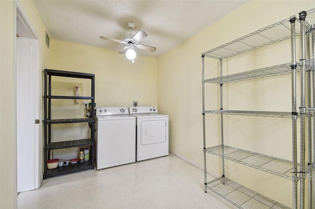 laundry room with ceiling fan, washer and dryer, and a textured ceiling