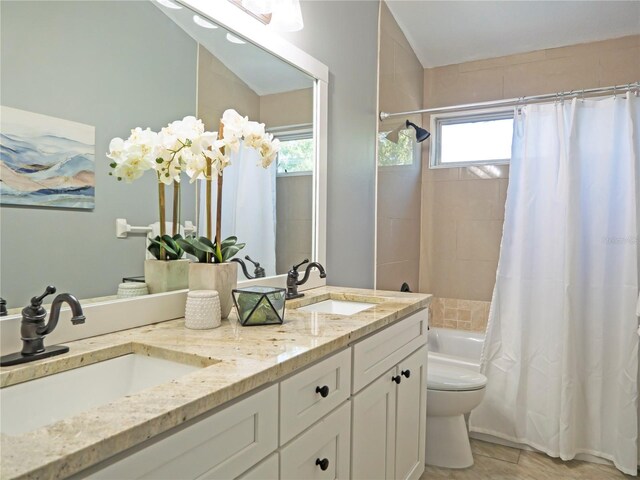 full bathroom with vanity, tile patterned flooring, shower / bathtub combination with curtain, and toilet