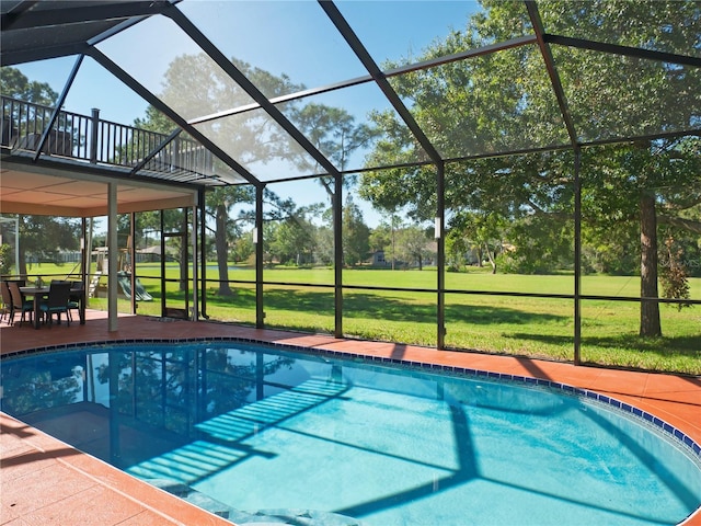 view of pool featuring a lanai, a patio area, and a lawn