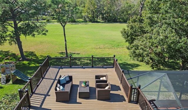 wooden deck with a lawn, a playground, and an outdoor hangout area