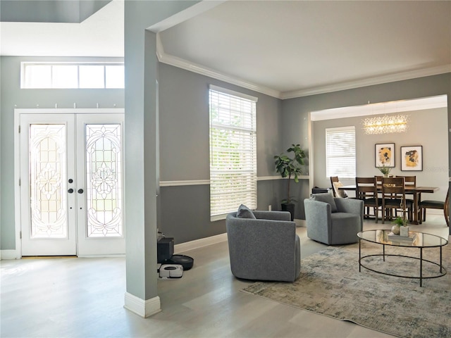 living room featuring hardwood / wood-style floors, a chandelier, french doors, and ornamental molding