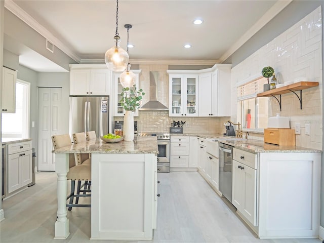 kitchen with pendant lighting, backsplash, white cabinets, a wealth of natural light, and stainless steel appliances