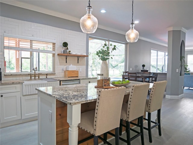 kitchen featuring a wealth of natural light and white cabinetry