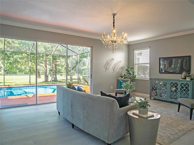 living room with wood-type flooring, ornamental molding, a wealth of natural light, and an inviting chandelier