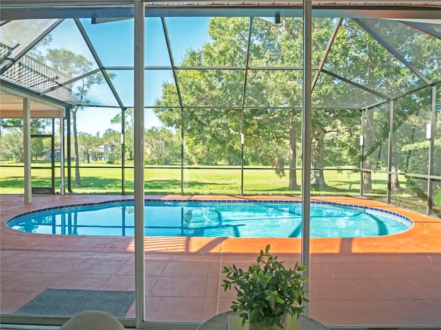 view of swimming pool with a lawn and a lanai