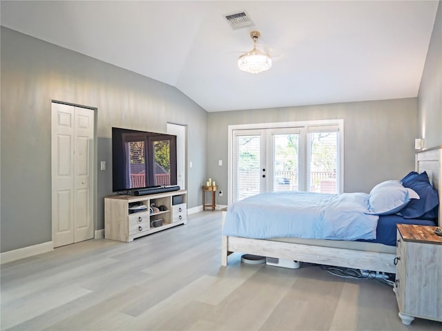 bedroom with light wood-type flooring, lofted ceiling, access to outside, and a closet