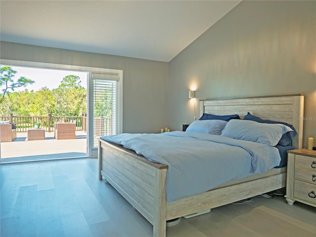 bedroom featuring access to outside, wood-type flooring, and vaulted ceiling