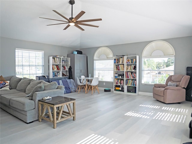 living room with ceiling fan, vaulted ceiling, and light hardwood / wood-style flooring