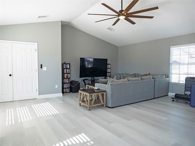 living room featuring light hardwood / wood-style floors, vaulted ceiling, and ceiling fan