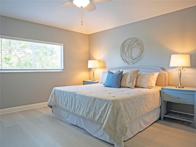 bedroom featuring ceiling fan, light hardwood / wood-style flooring, and vaulted ceiling