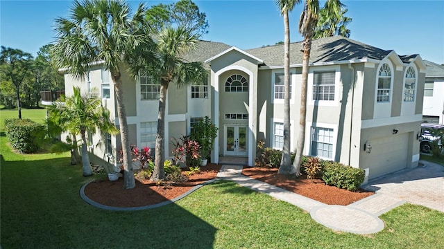 view of front of home featuring a garage, a front yard, and french doors