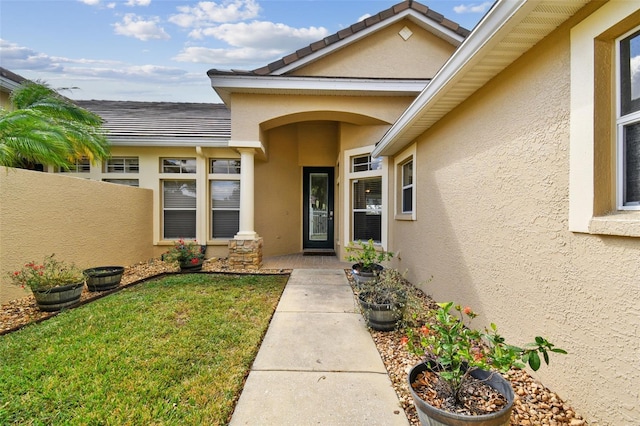 entrance to property featuring a lawn