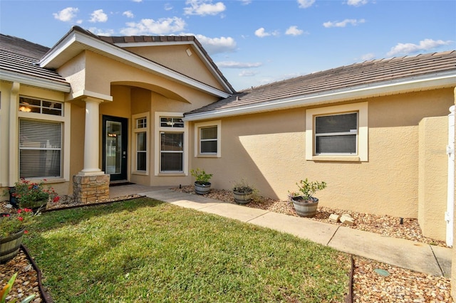 entrance to property with a lawn