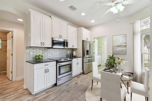 kitchen with white cabinets, ceiling fan, light wood-type flooring, tasteful backsplash, and stainless steel appliances