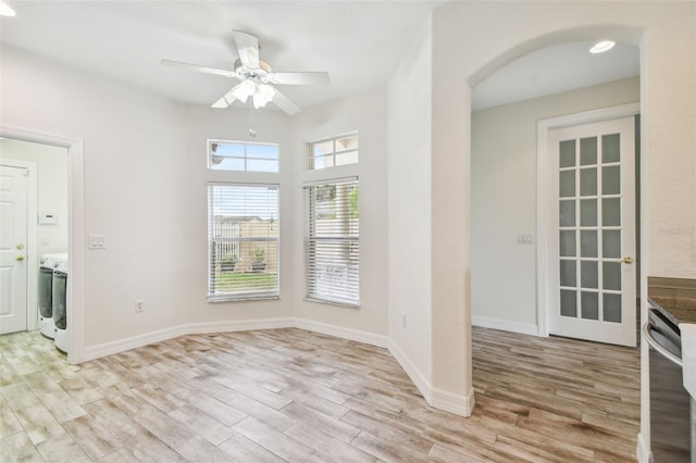 interior space with ceiling fan, washer / clothes dryer, and light hardwood / wood-style flooring