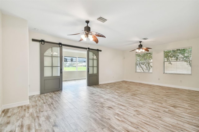 unfurnished room with ceiling fan, plenty of natural light, and light wood-type flooring